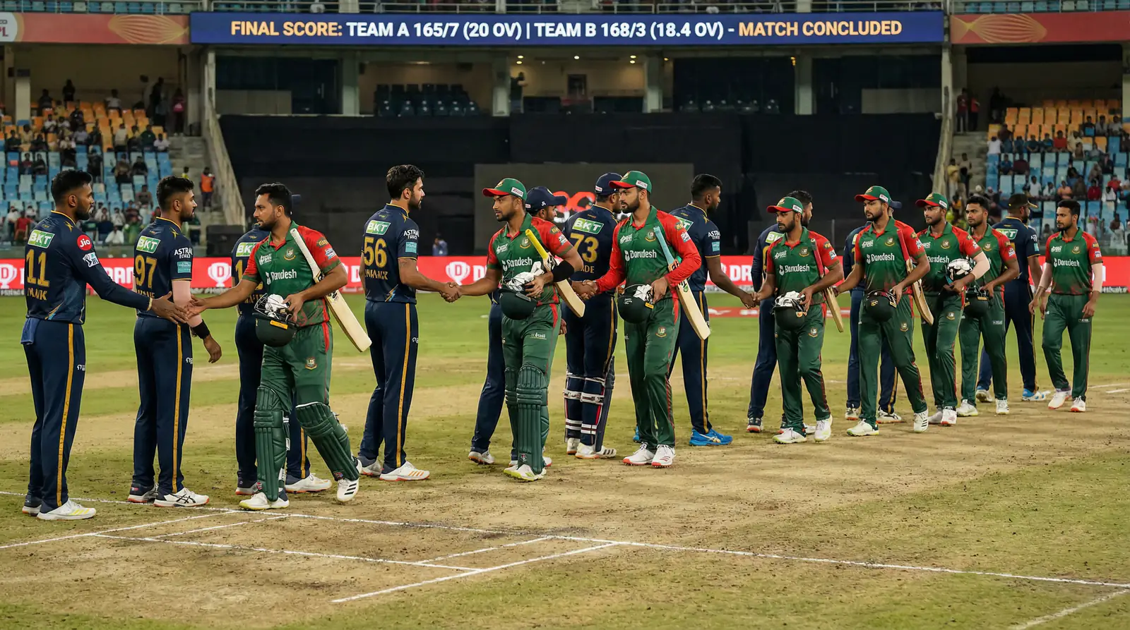 Two cricket teams shaking hands on the pitch after a match with the scoreboard visible in the background